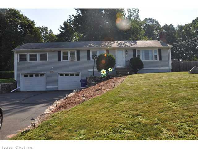 a front view of house with yard and trees in the background
