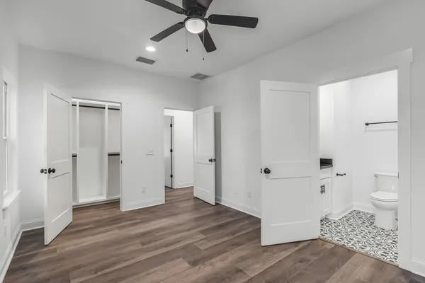 a view of a bathroom with wooden floor and a ceiling fan