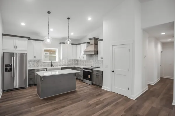 a large kitchen with stainless steel appliances kitchen island a large counter top and a sink