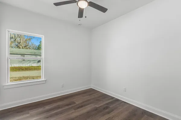 an empty room with a window and wooden floor
