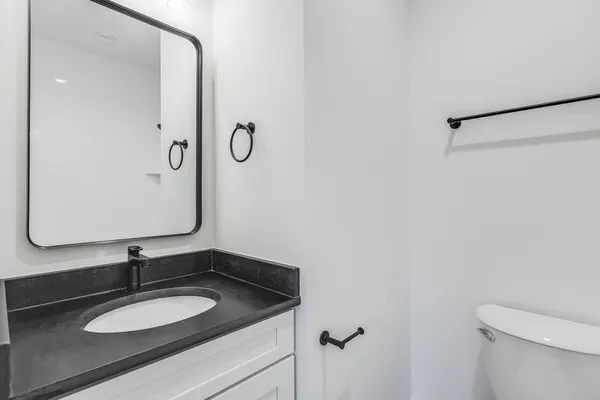 a bathroom with a granite countertop sink and a mirror