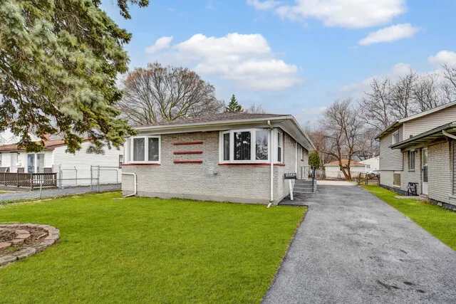 a front view of a house with a yard and trees