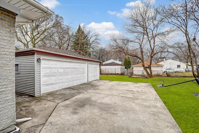 a view of a house with a yard and large tree