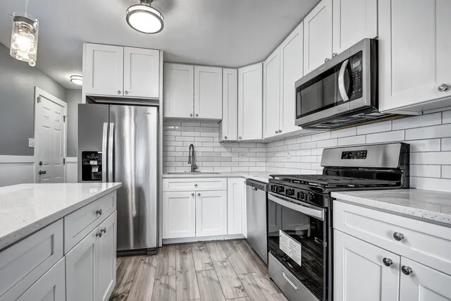 a kitchen with stainless steel appliances granite countertop a stove a microwave and a refrigerator