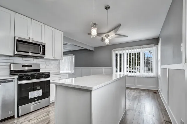 a kitchen with stainless steel appliances a stove sink microwave and cabinets