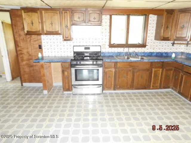 a kitchen with granite countertop a sink a counter top space and cabinets