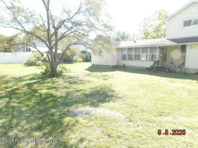 a view of a house with a yard and covered with snow