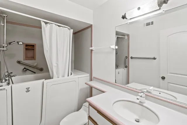 a bathroom with a sink a toilet and a mirror
