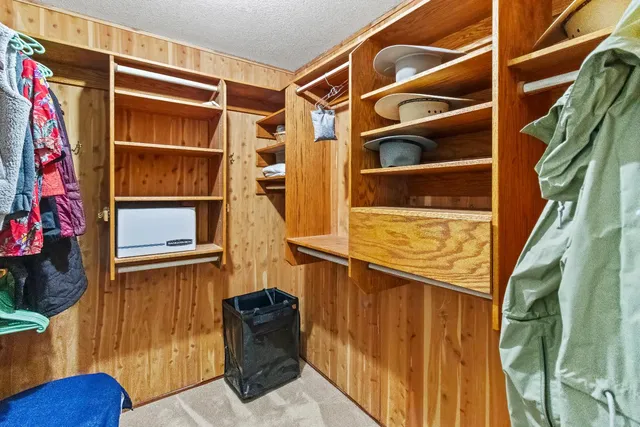 a view of walk in closet with clothes and shoes