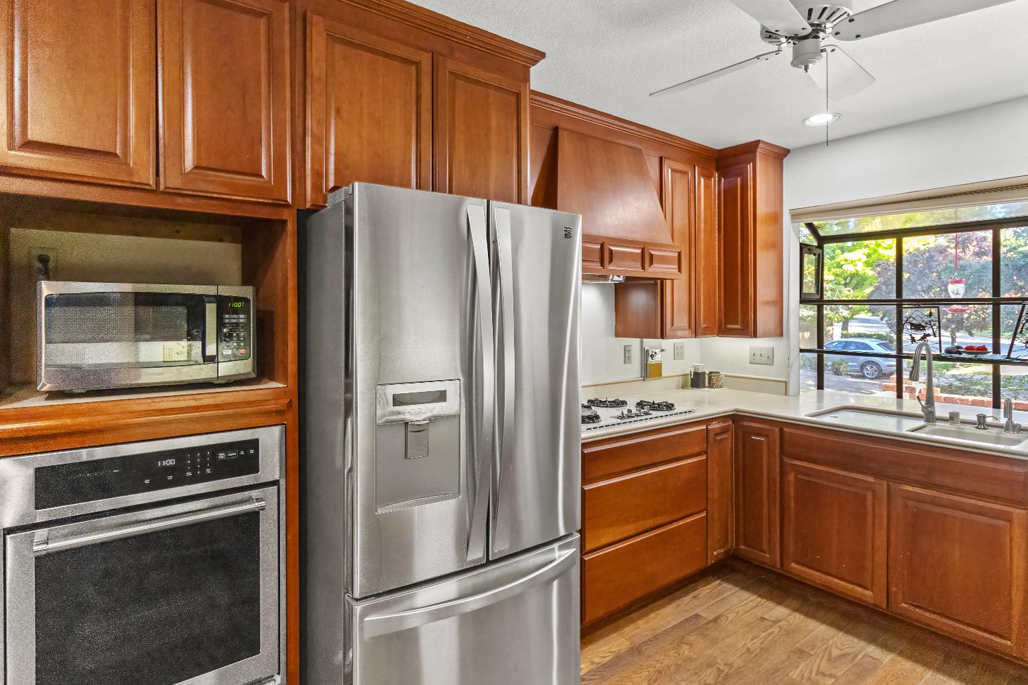 6543 Crosswoods Circle Citrus Heights, CA 95621 - Photo 9 of 33 a kitchen with stainless steel appliances granite countertop a refrigerator a sink dishwasher a stove and white countertops with wooden floor
