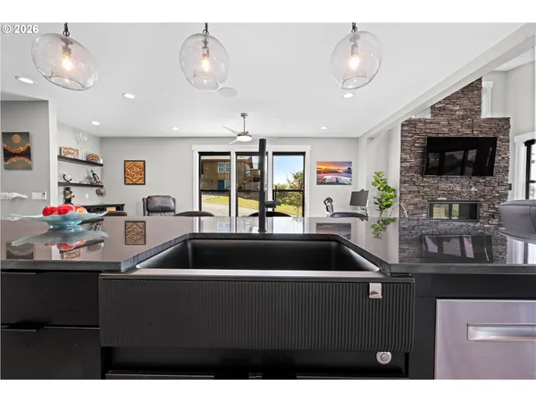 a open kitchen with stainless steel appliances kitchen island granite countertop a table chairs and a refrigerator