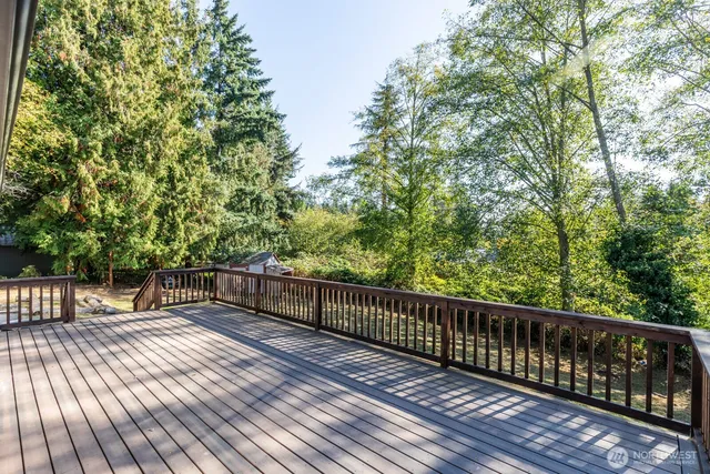 a view of deck with wooden floor and trees