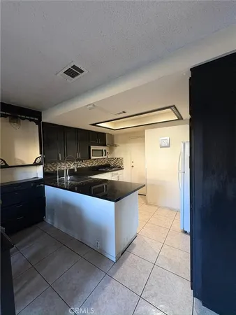 a kitchen with stainless steel appliances granite countertop a sink and a refrigerator
