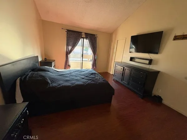 a bedroom with a bed tv and a window