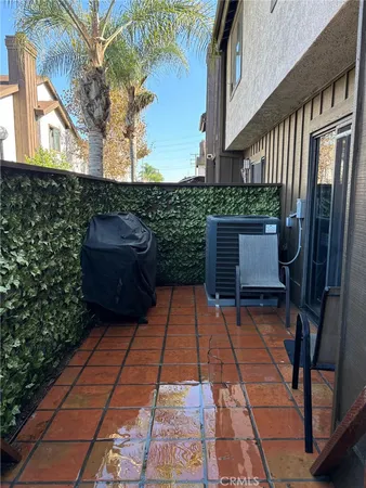 a backyard of a house with barbeque oven and outdoor seating