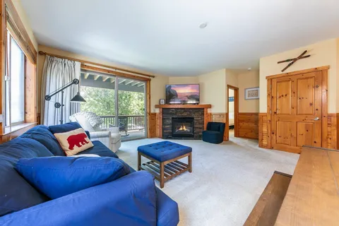 a living room with furniture fireplace and a large window