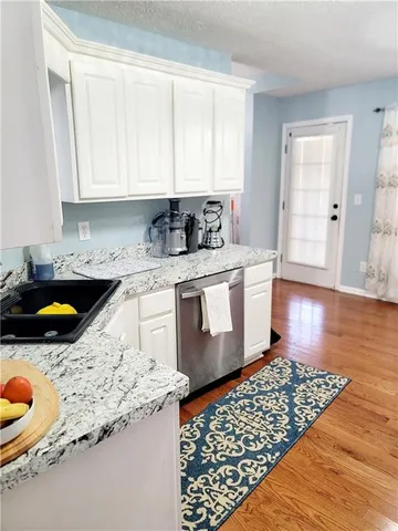 a kitchen with stainless steel appliances granite countertop a sink stove and cabinets