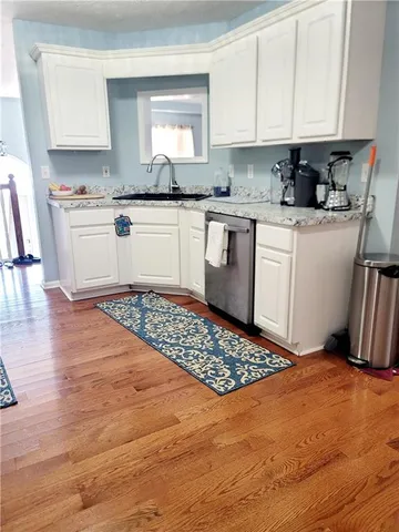 a kitchen with stainless steel appliances granite countertop a sink stove refrigerator and cabinets