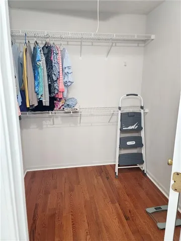 a view of walk in closet with clothes and shoes