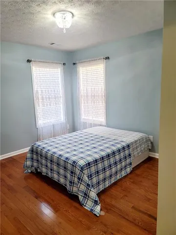 a bedroom with a bed and wooden floor