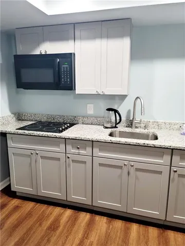 a kitchen with stainless steel appliances granite countertop a sink a stove and a microwave