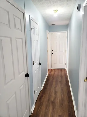 a view of a hallway with wooden floor and staircase