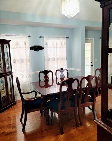 a view of a a dining room with furniture window and wooden floor