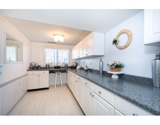 159 Beach Avenue Hull, MA 02045 - Photo 14 of 28 a kitchen with cabinets a sink and a stove with wooden floor