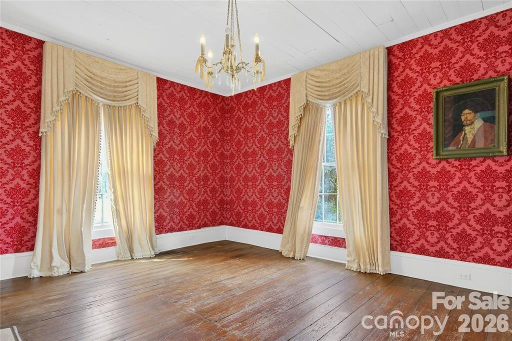 11124 Eastfield Road Huntersville, NC 28078 - Photo 12 of 41 a view of an empty room with wooden floor and a window