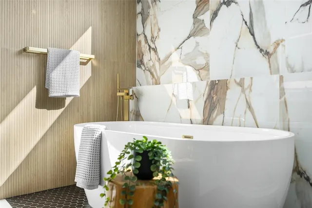 a bathroom with a white tub shower and sink