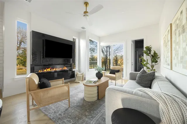 a living room with furniture a flat screen tv and large window