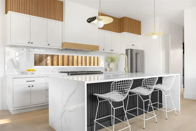 a kitchen with a stove a sink and white cabinets