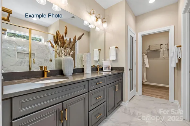 a spacious bathroom with a granite countertop sink a mirror and a shower