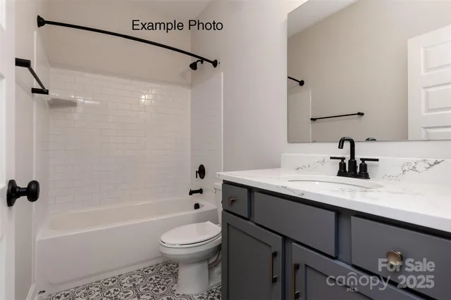 a bathroom with a granite countertop sink a toilet and shower