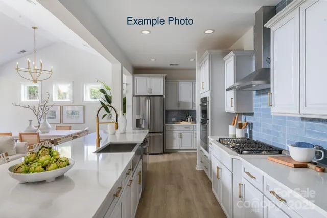 a kitchen with kitchen island granite countertop a white cabinets and stove