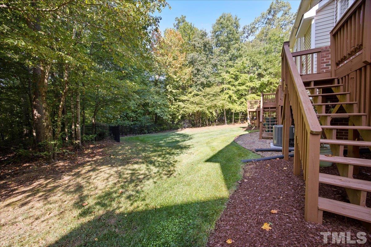 716 Saratoga Drive Durham, NC 27704 - Photo 28 of 30 a view of a yard with plants and a brick wall