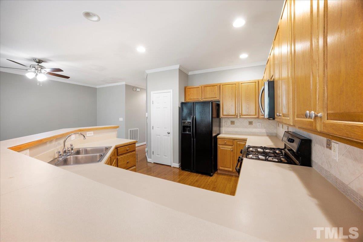 716 Saratoga Drive Durham, NC 27704 - Photo 9 of 30 a kitchen with stainless steel appliances granite countertop a sink a refrigerator and a stove