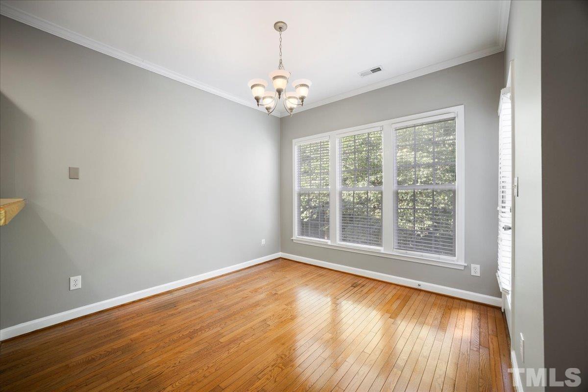 716 Saratoga Drive Durham, NC 27704 - Photo 10 of 30 a view of an empty room with wooden floor and a window