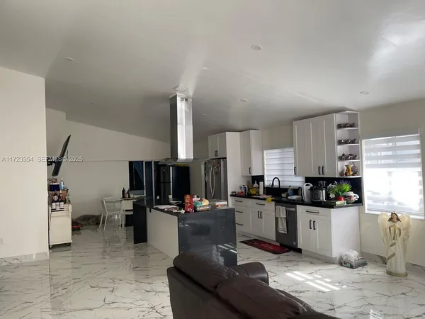a kitchen with granite countertop a sink dishwasher stove and cabinets