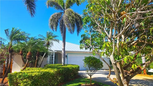 a front view of a house with a garden and yard