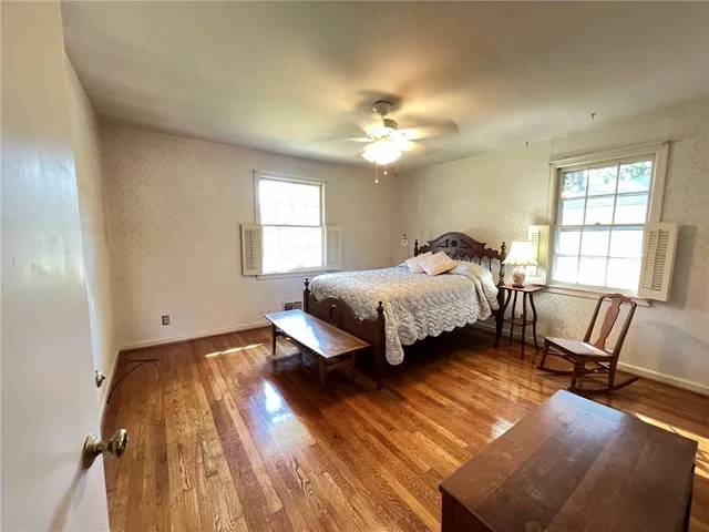 a bedroom with a bed window and a chair