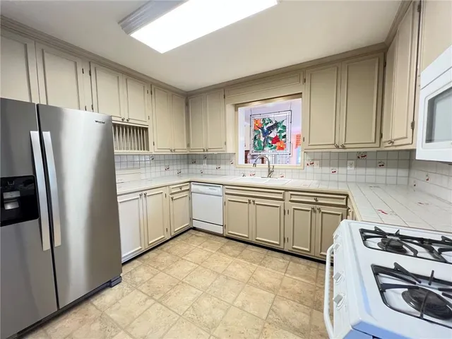 a kitchen with a refrigerator sink and cabinets
