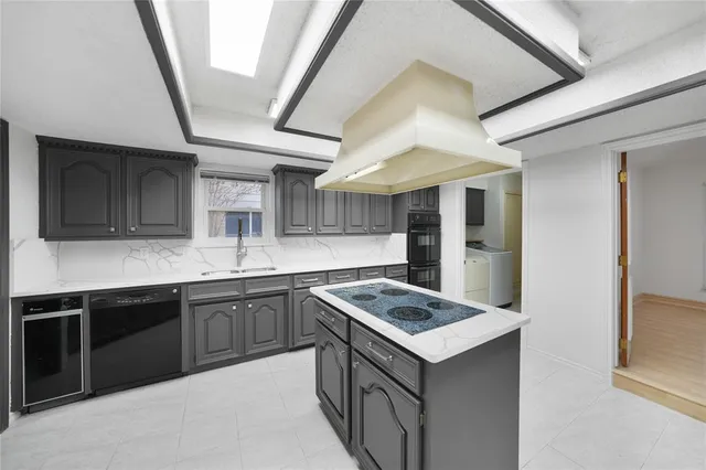 a kitchen with kitchen island a sink and refrigerator