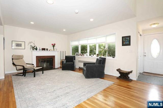 84 12th Street Cresskill, NJ 07626 - Photo 3 of 45 a living room with furniture a fireplace and a table