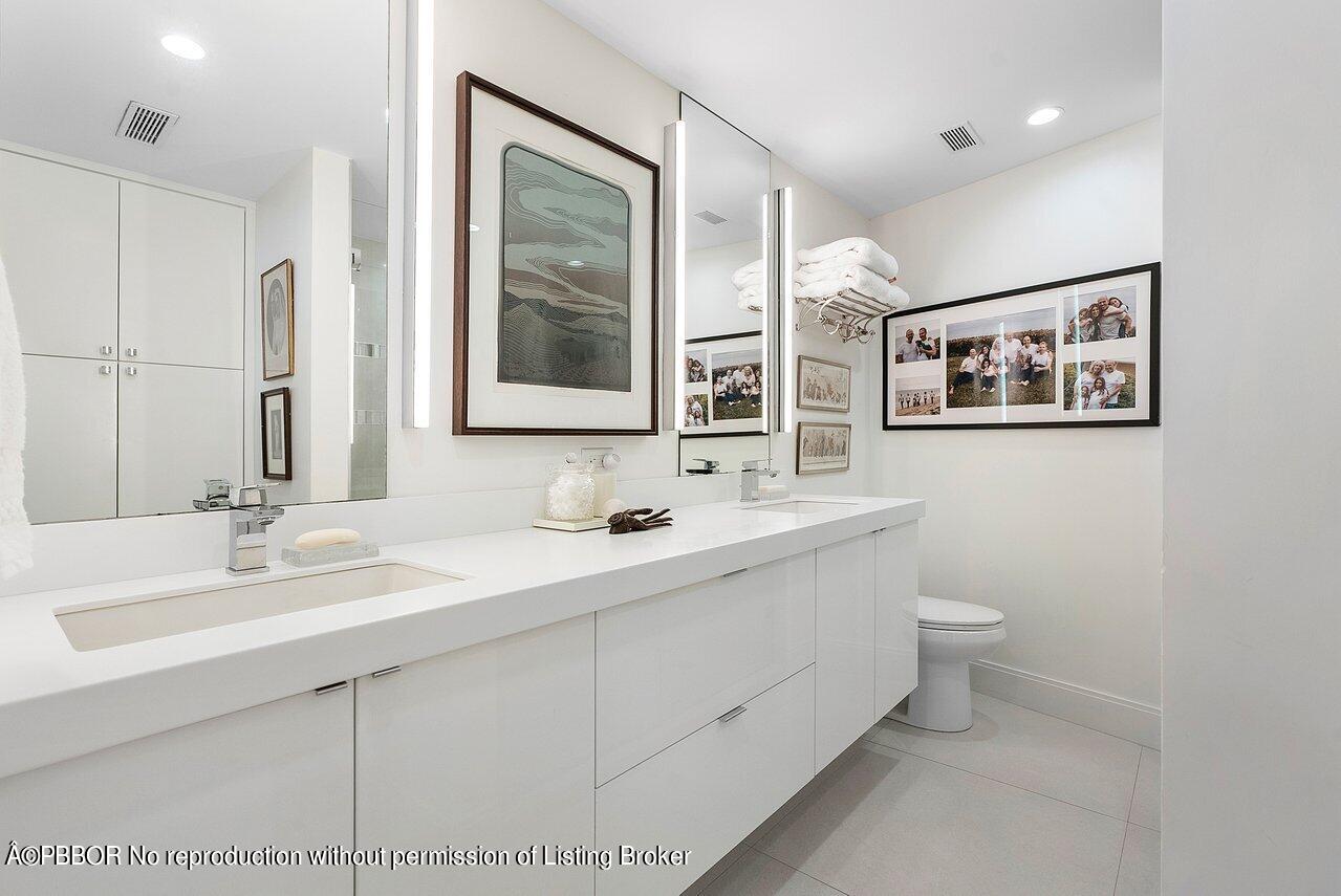 44 Cocoanut Row, Unit 122B Palm Beach, FL 33480 - Photo 13 of 21 a bathroom with a double vanity sink mirror and toilet
