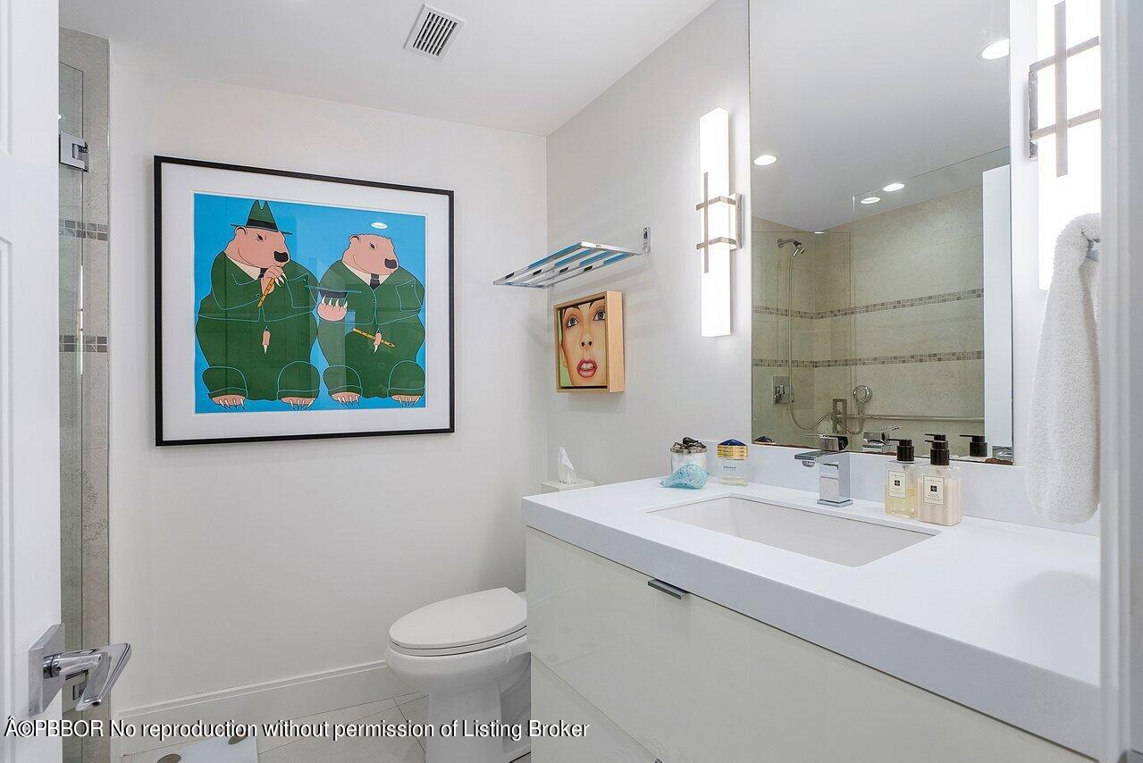 44 Cocoanut Row, Unit 122B Palm Beach, FL 33480 - Photo 14 of 21 a bathroom with a toilet a sink and mirror