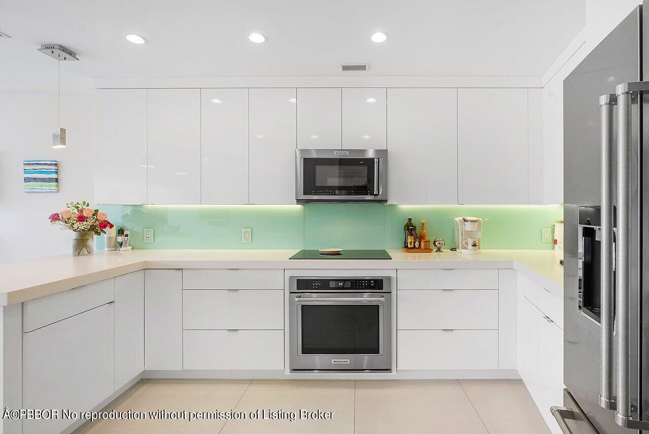 44 Cocoanut Row, Unit 122B Palm Beach, FL 33480 - Photo 5 of 21 a kitchen with granite countertop a stove a sink and a refrigerator