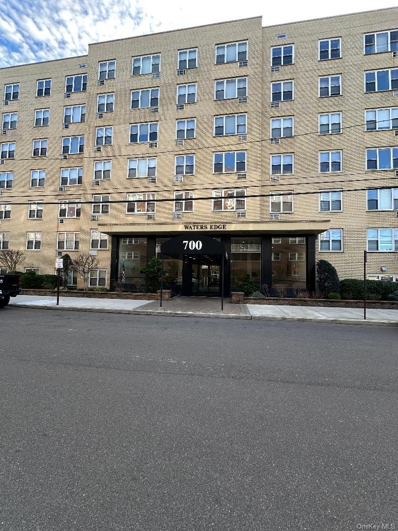 700 Shore Road, Unit 6EE Long Beach, NY 11561 - Photo 1 of 13 a front view of a building with lot of cars parked