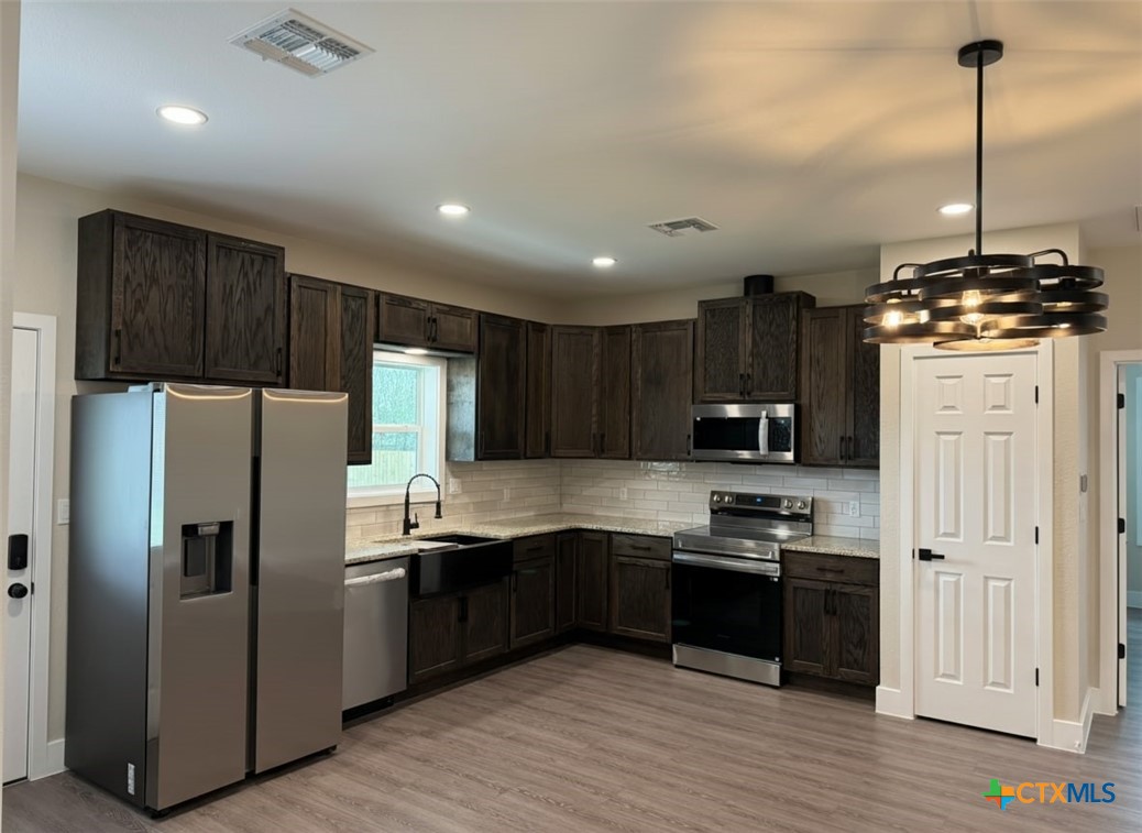 205 Haller Street Yoakum, TX 77995 - Photo 5 of 12 a kitchen with kitchen island a sink stainless steel appliances and cabinets