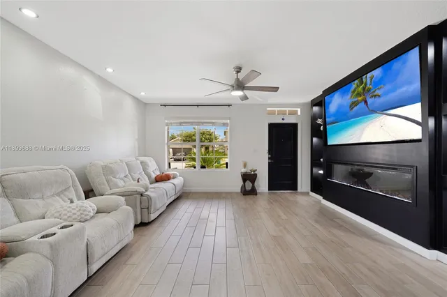 a kitchen with stainless steel appliances a sink dishwasher a refrigerator a stove top oven a dining table and chairs with wooden floor